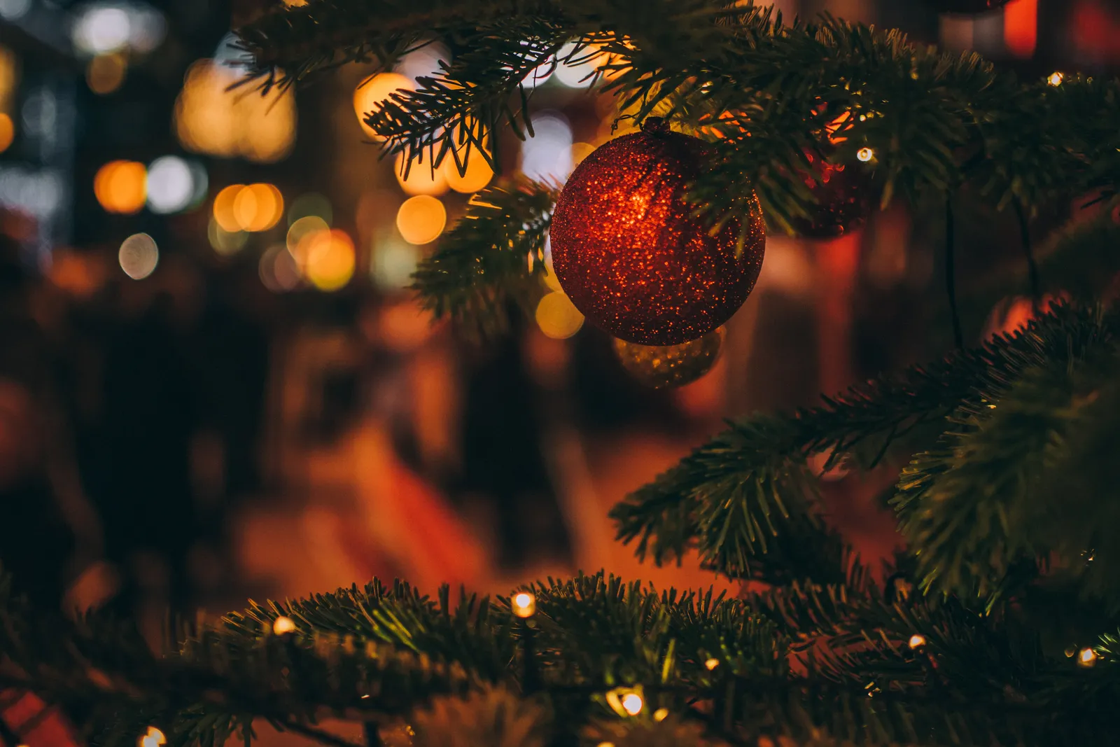 Christmas tree decorated with a red ornament and warm lights