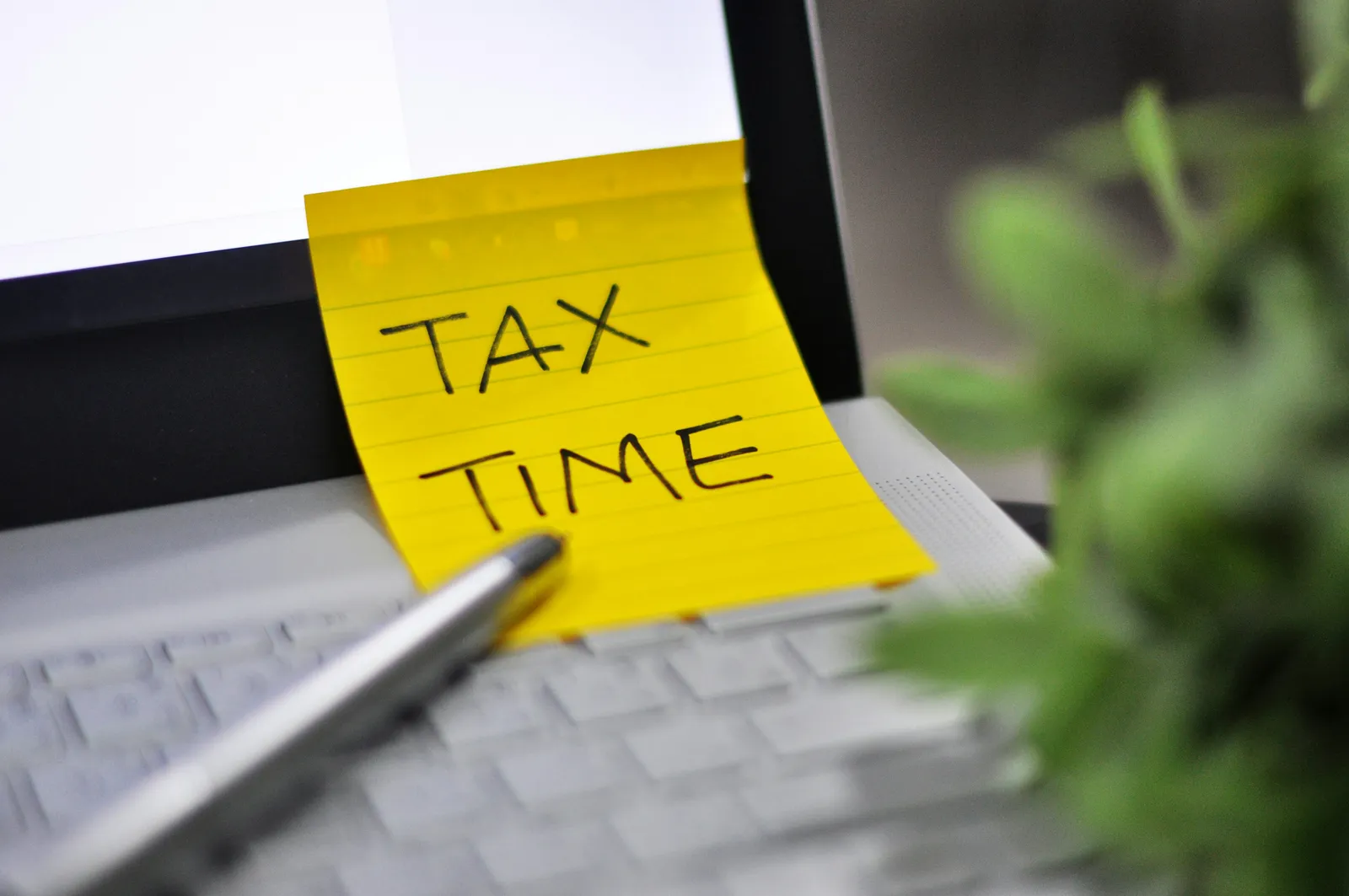 Yellow sticky note with tax time written on it.